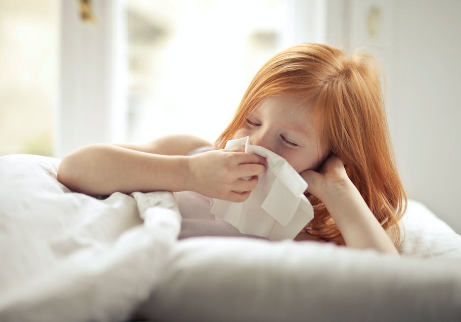 An image depicting a person with a tissue blowing their nose, symbolizing the common cold.